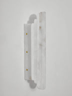 Side view of the unlit Clérachic alabaster sconce, showing its stepped stone panels and the narrow plate fixed with brass-coloured screws.