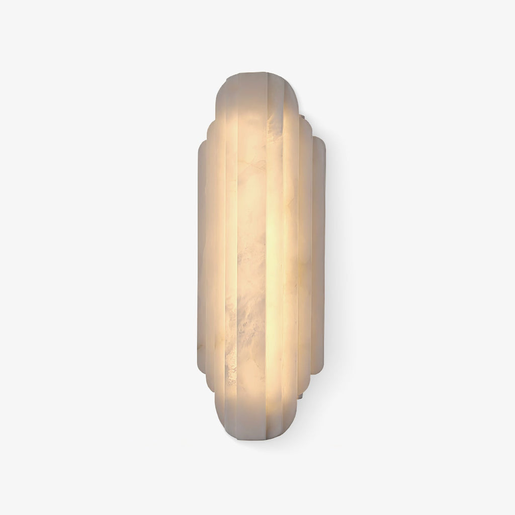 The taller Clérachic alabaster sconce lit warm on a white backdrop, with a darker band of veining running down the stone.