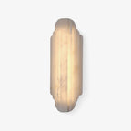 The taller Clérachic alabaster sconce lit warm on a white backdrop, with a darker band of veining running down the stone.