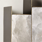 Close-up of the Clérachic Alabaster Wall Sconce, showing the brass-edged bezel where dark metal meets crystalline stone.