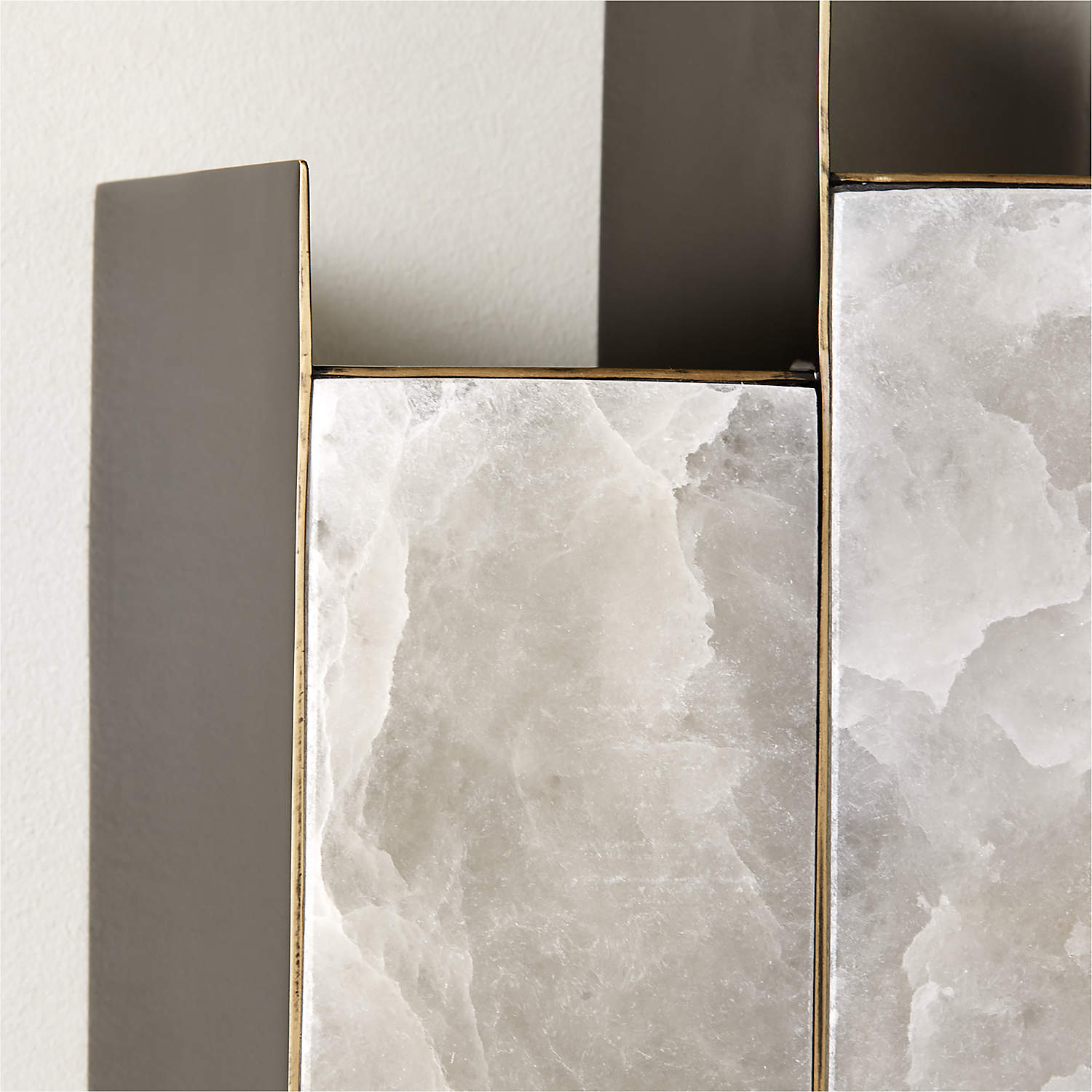 Close-up of the Clérachic Alabaster Wall Sconce, showing the brass-edged bezel where dark metal meets crystalline stone.