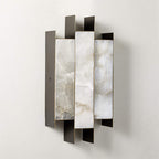 Clérachic Alabaster Wall Sconce unlit on a wall, the cool grey-white veining of its three natural stone panels on show.