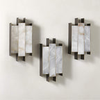 Three Clérachic Alabaster Wall Sconces hung in a staggered group on one wall, each panel carrying its own stone veining.