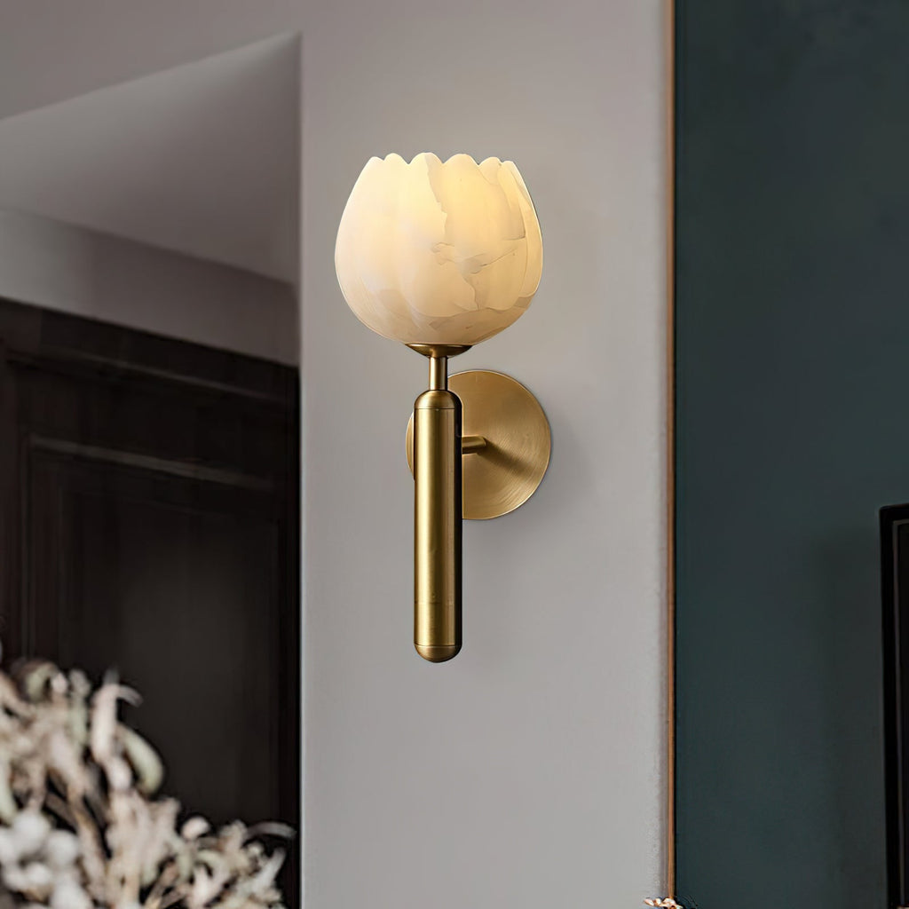 Close three-quarter view of the brass Clérachic alabaster wall sconce, its scalloped stone rim glowing on a corner wall.