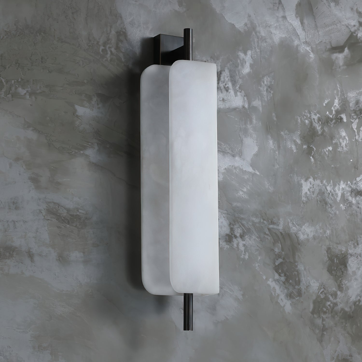 The Clérachic Alabaster Wall Sconce against grey plaster, 52 cm tall and standing just 12 cm off the wall so it clears a passing shoulder.