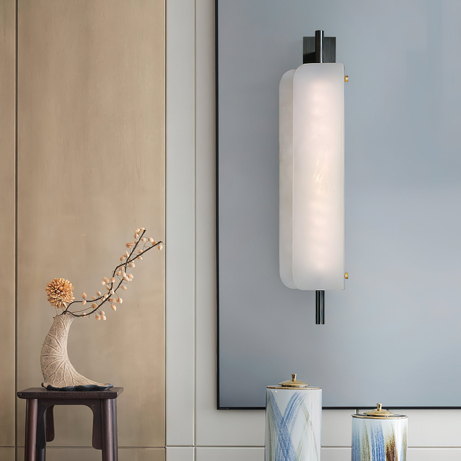 Clérachic Alabaster Wall Sconce lit beside a framed blue panel in an entry, throwing a soft wash up and down the wall.
