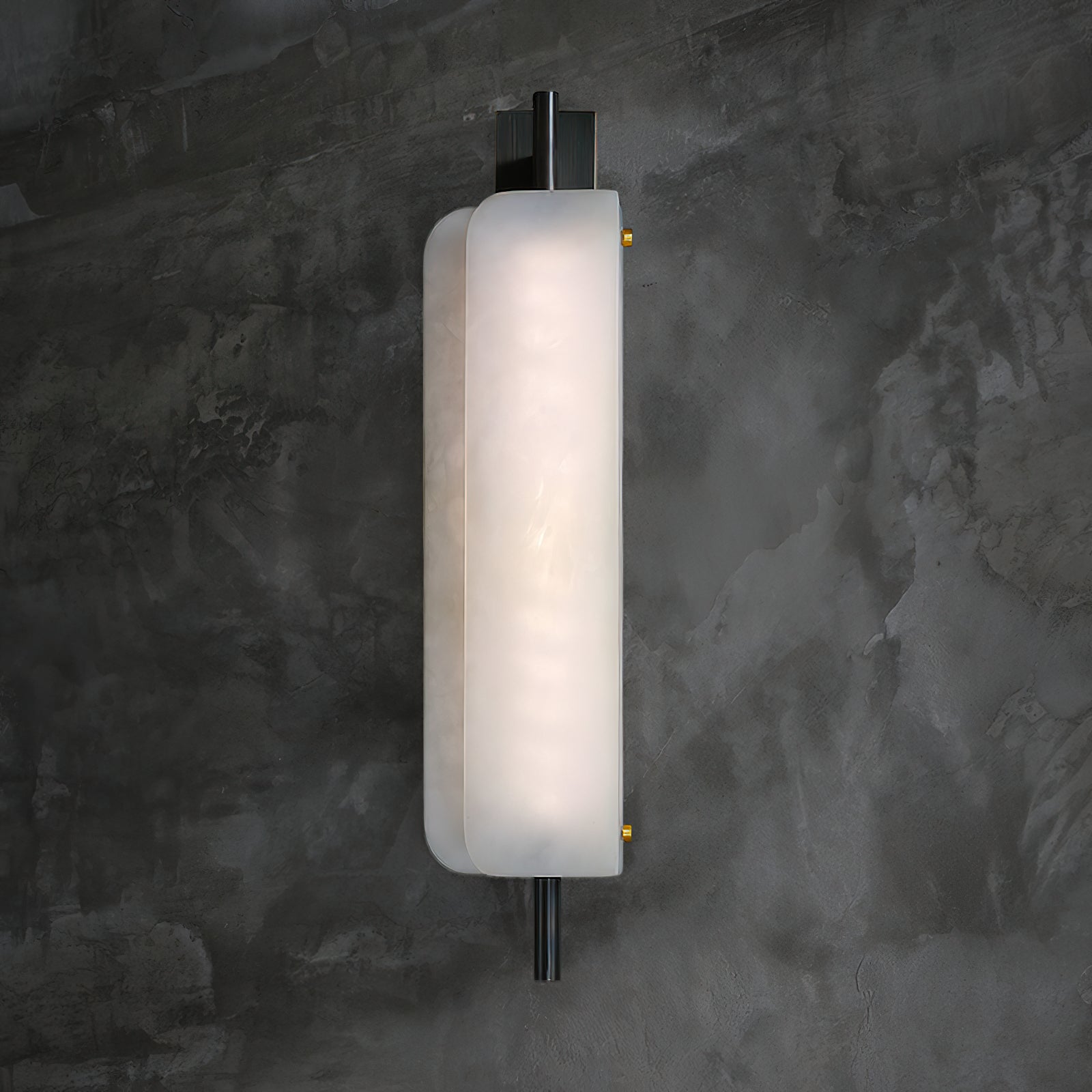Clérachic Alabaster Wall Sconce lit against a dark concrete wall, the alabaster face even and bright from the rod above to the rod below.