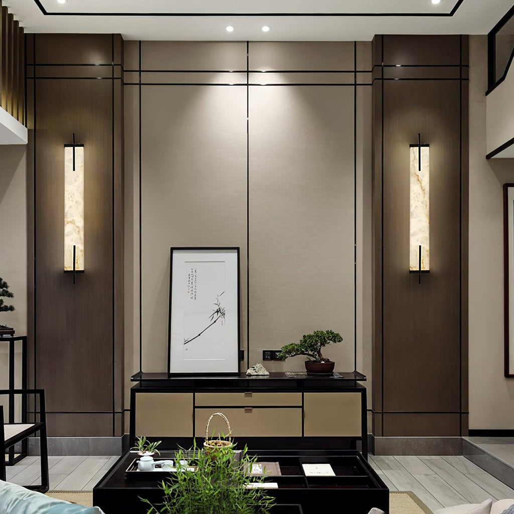 Two Clérachic alabaster wall lights flank a framed ink drawing above a console in a wood-panelled living room.