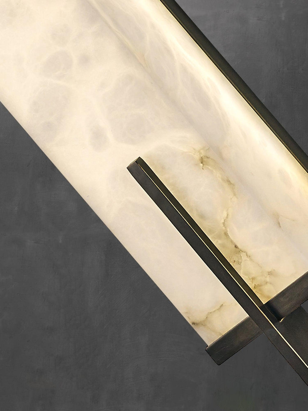 Close view of the cloudy veining in the alabaster panel and the thin black bar that crosses the corner of this Clérachic wall light.
