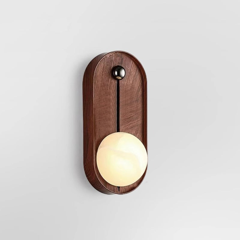 Front view of the Clérachic Alabaster Wall Sconce in oval, the lit globe sitting low so the light falls down the wall.