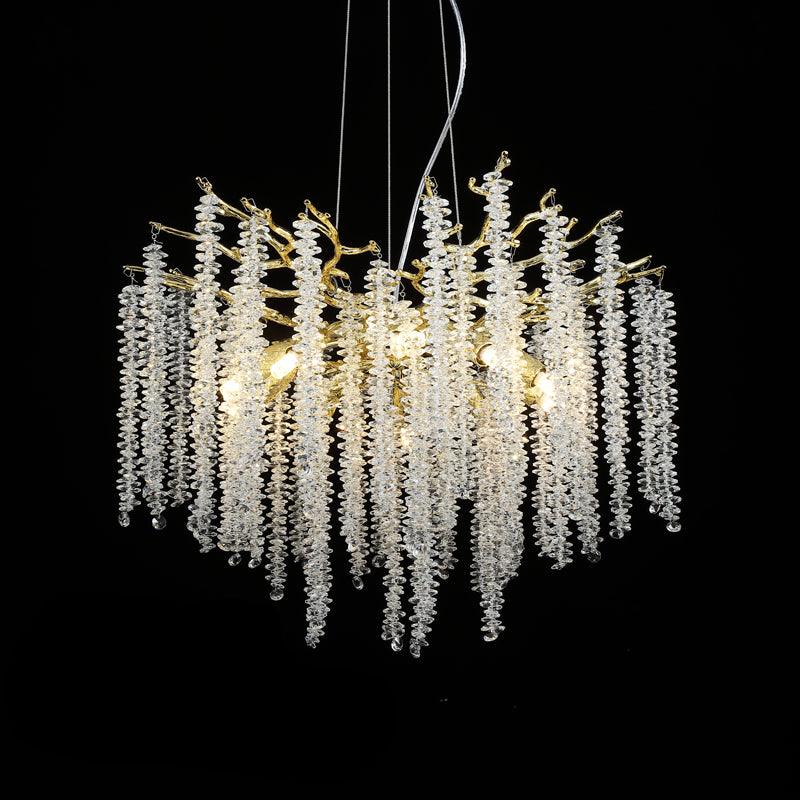 Clérachic Albero chandelier, clear crystal strands cascading from a gold branch frame on black.