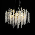 Clérachic Albero chandelier, clear crystal strands cascading from a gold branch frame on black.