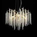 Clérachic Albero chandelier, clear crystal strands cascading from a gold branch frame on black.