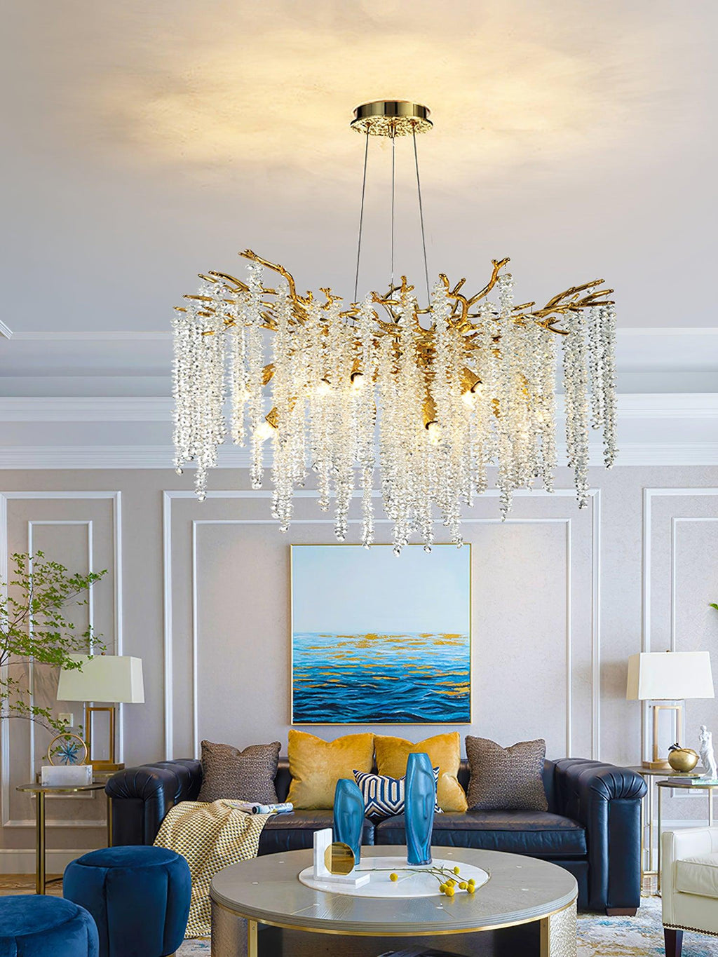 Clérachic Albero chandelier lit in a classical room above a navy sofa and a seascape painting.