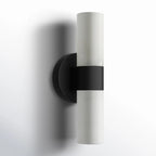 Clérachic Alight wall lamp in black, viewed at an angle so the collar reads as a dark band across pale stone.