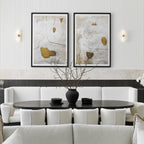 Clérachic Alight sconces flanking two framed artworks above a pale banquette in a fluted-panel dining room.
