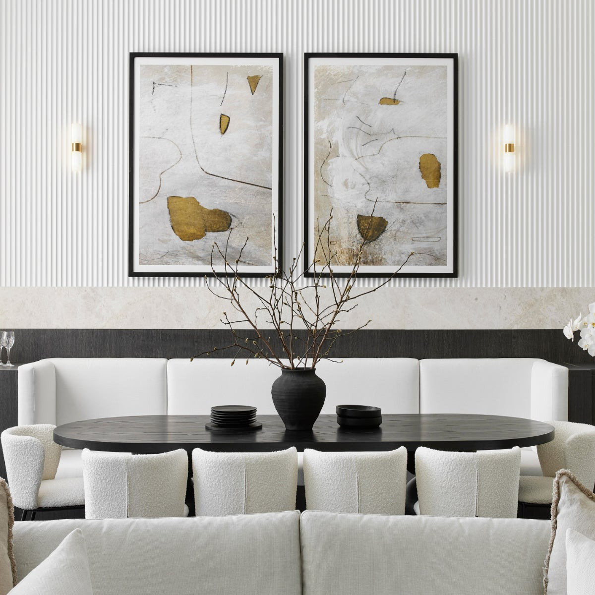 Clérachic Alight sconces flanking two framed artworks above a pale banquette in a fluted-panel dining room.