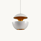White aluminium bowl pendant split into two halves with a gold interior, hung on a thin white cord on a plain backdrop, from Clérachic.