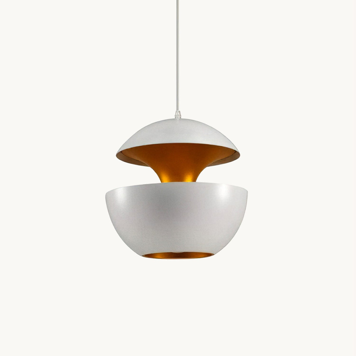 White aluminium bowl pendant split into two halves with a gold interior, hung on a thin white cord on a plain backdrop, from Clérachic.