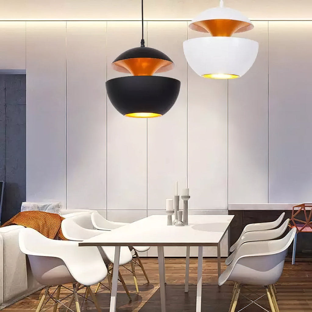Black and white bowl pendants lit above a white table, seen from slightly below, both from Clérachic.