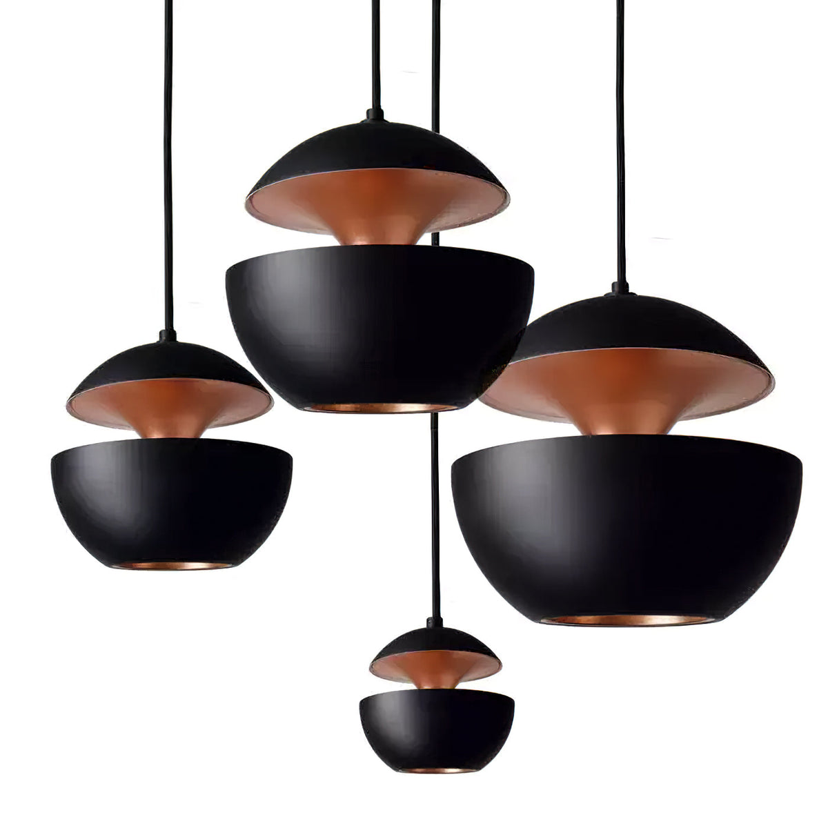 Four black Clérachic pendants of different sizes hung at staggered heights, their gold interiors showing, on a white backdrop.