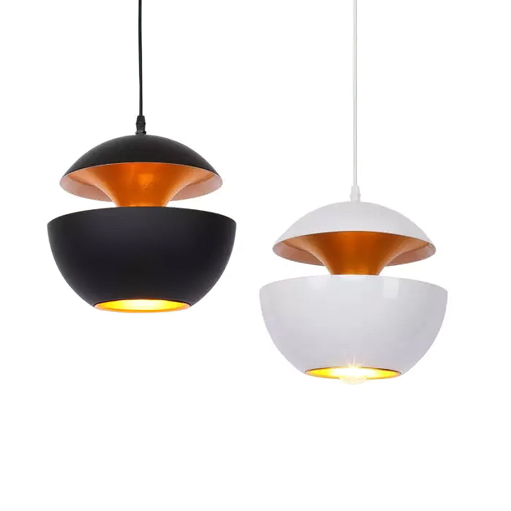 A black and a white Clérachic pendant with gold interiors, both lit, shown together on a white backdrop.