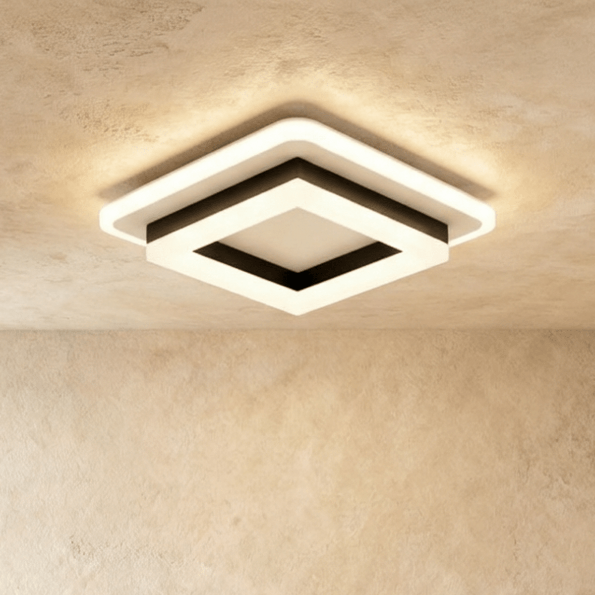 Clérachic stacked square ceiling light in black and frosted white acrylic, switched on and glowing warm against a limewash ceiling.