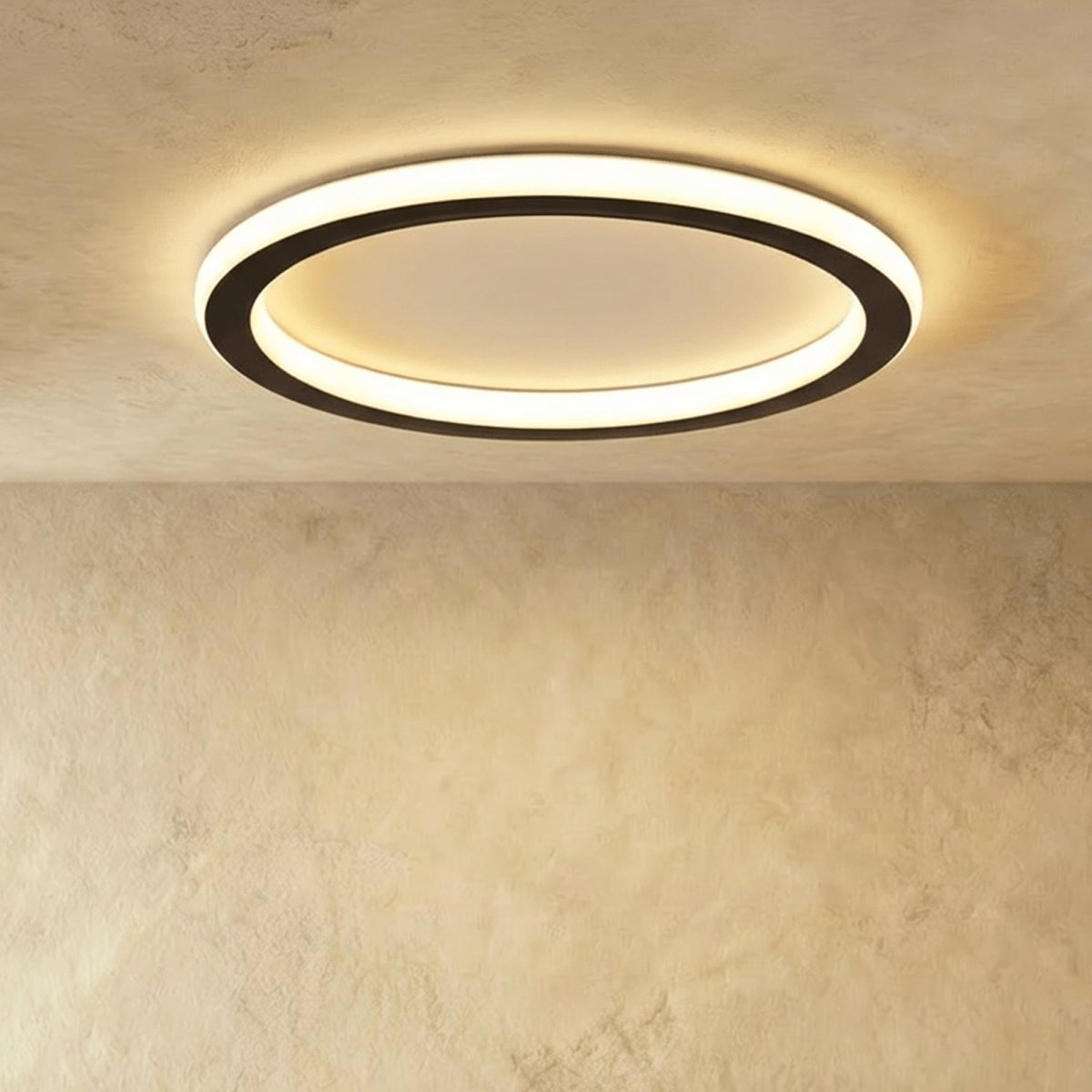 Clérachic slim round ceiling ring with a black outer band and a frosted white glowing halo, lit against a plastered ceiling.