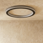 Clérachic slim round ceiling ring in black with a frosted white acrylic band, switched off against a limewash ceiling.