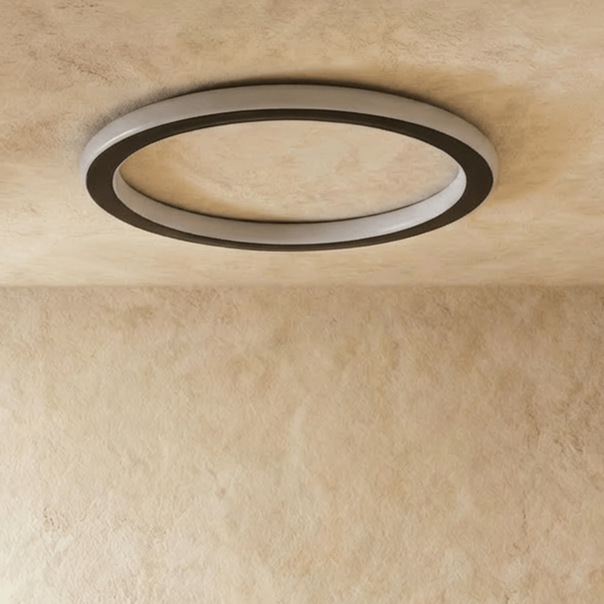 Clérachic slim round ceiling ring in black with a frosted white acrylic band, switched off against a limewash ceiling.