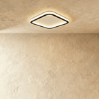 Clérachic slim rounded-square ceiling light with a black frame and a frosted white glow, mounted high on a limewash ceiling.