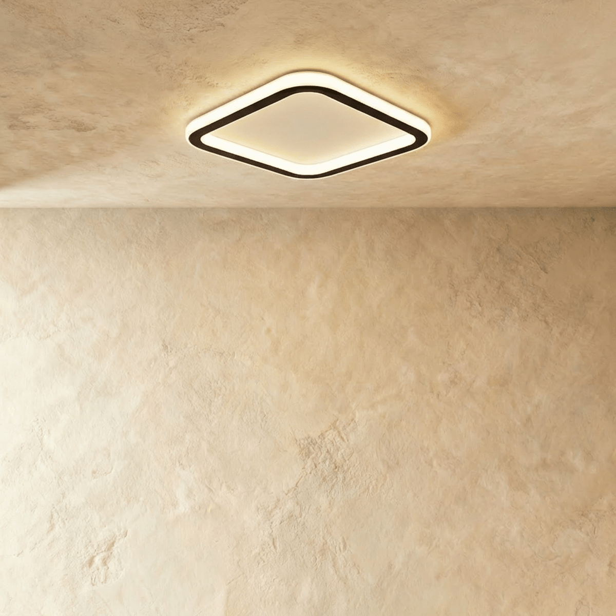 Clérachic slim rounded-square ceiling light with a black frame and a frosted white glow, mounted high on a limewash ceiling.