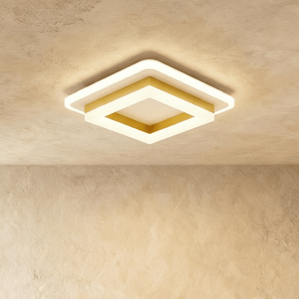 Clérachic stacked square ceiling light with a gold-finish frame and frosted white acrylic tiers, glowing warm on a ceiling.