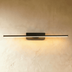 Clérachic longest black bar wall light in the range, a slim lit arm spanning most of the frame on a limewash wall.