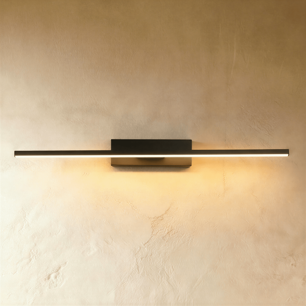 Clérachic longest black bar wall light in the range, a slim lit arm spanning most of the frame on a limewash wall.