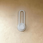 Clérachic white oval ring wall light switched off, a slim loop on a round backplate against a textured limewash wall.