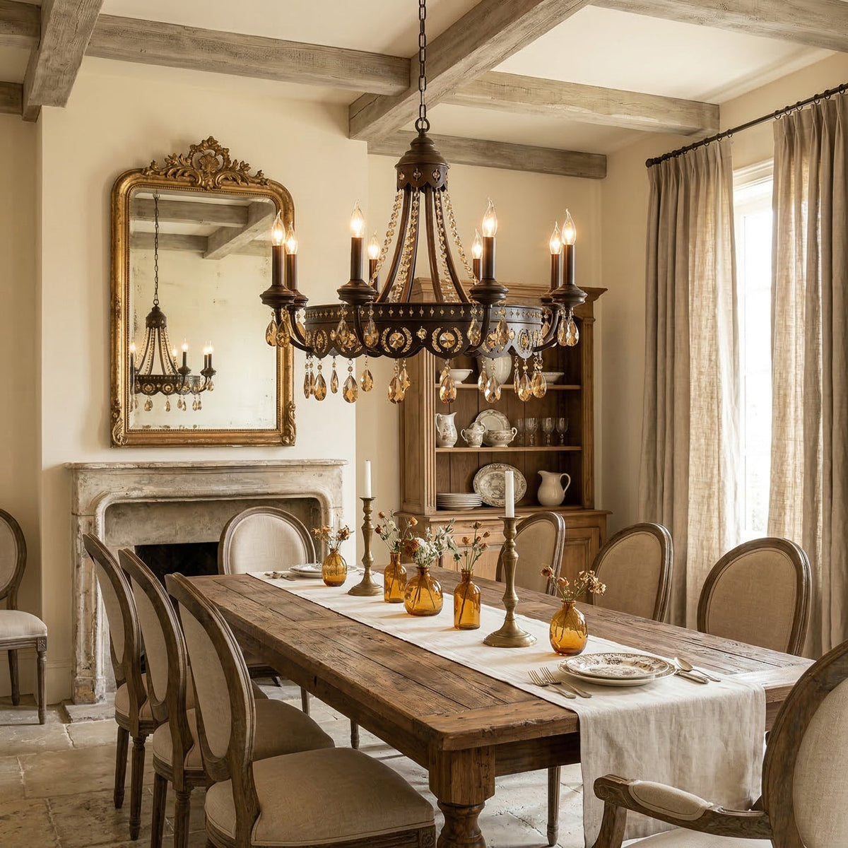 Clérachic bronze-finish chandelier above a long rustic dining table in a beamed room with a stone fireplace.