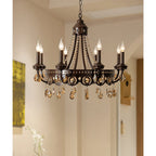 Clérachic chandelier with amber crystal drops lit in a pale hallway, with an arched doorway and a painting at the edge.