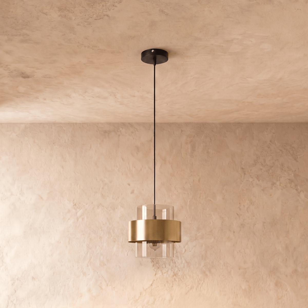 Straight-on view of the Clérachic cylinder pendant light, its clear glass shade and brass band suspended below a plain ceiling.