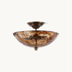 This Clérachic semi-flush ceiling light on a plain white backdrop, with a swirled amber-and-brown glass bowl and a bronze canopy.