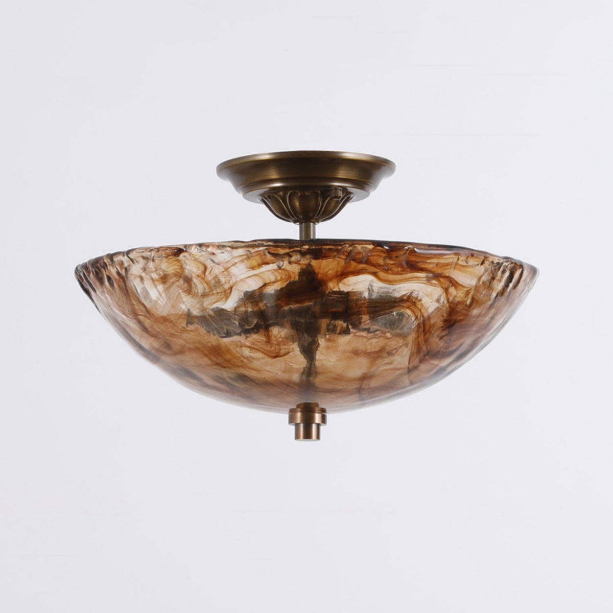 Side-on view of this Clérachic ceiling light, with the wide, shallow amber glass bowl and bronze fitting against a soft grey background.