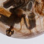 Close view of the swirled brown and amber glass and the bronze finial at the base of this Clérachic ceiling light.