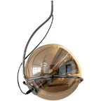 Studio view of the Clérachic Amber Glass Dome Pendant Light, a chrome arm wrapping the amber globe on white.