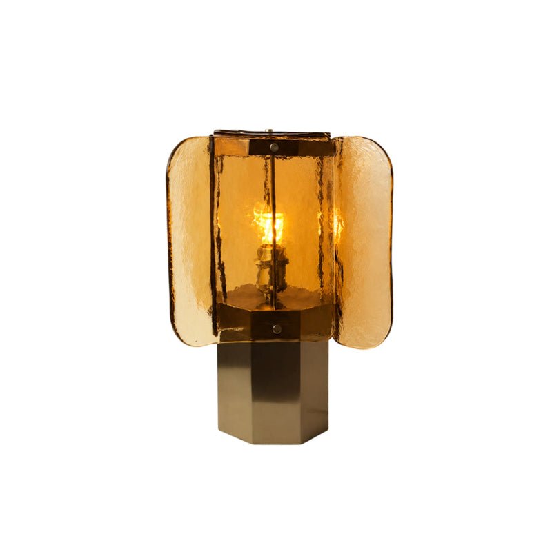 Amber glass Clérachic table lamp lit and cut out on white, with the brass octagonal base and four rounded panels visible.