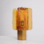 Unlit Clérachic table lamp on a white surface, showing the rippled amber glass panels and the bulb holder behind them.