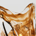 Close view of the streaked amber and clear glass at the flared rim of this Clérachic wall lamp shade.