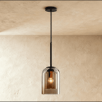 A front view shows the Clérachic smoky gray glass pendant lit softly, its bulb visible through tinted glass.