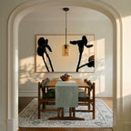 A Clérachic amber glass pendant hangs in an archway, glowing before a large abstract floral painting.