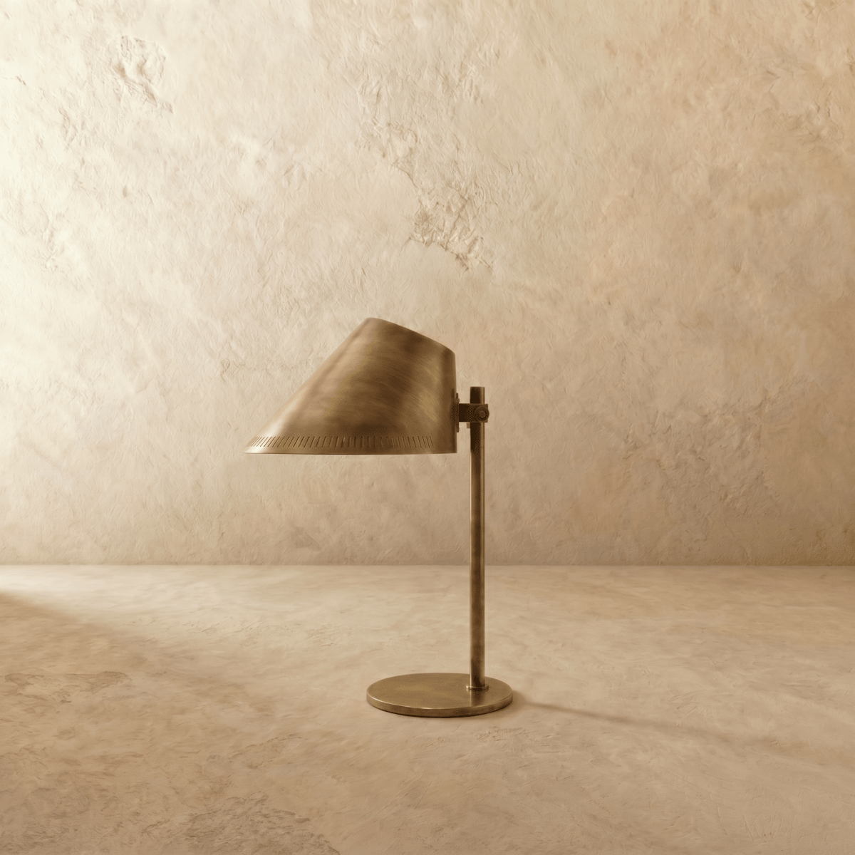 Clérachic table lamp in satin brass, front view of the angled cone shade and round metal base.