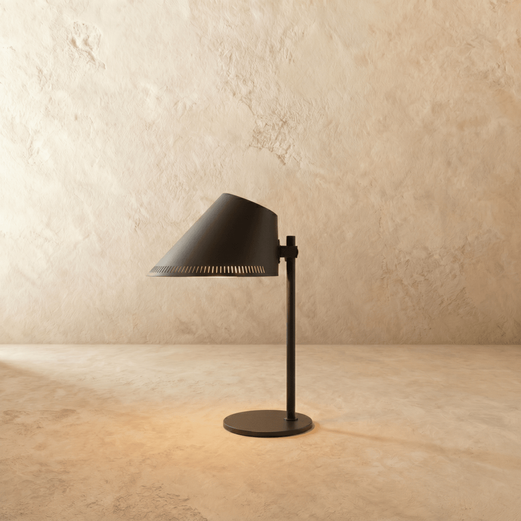 Clérachic table lamp in matte black with an angled cone shade on a slender stem and round base.